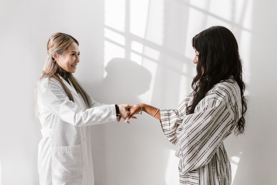 A friendly consultation between a doctor and patient in a bright, white room setting.